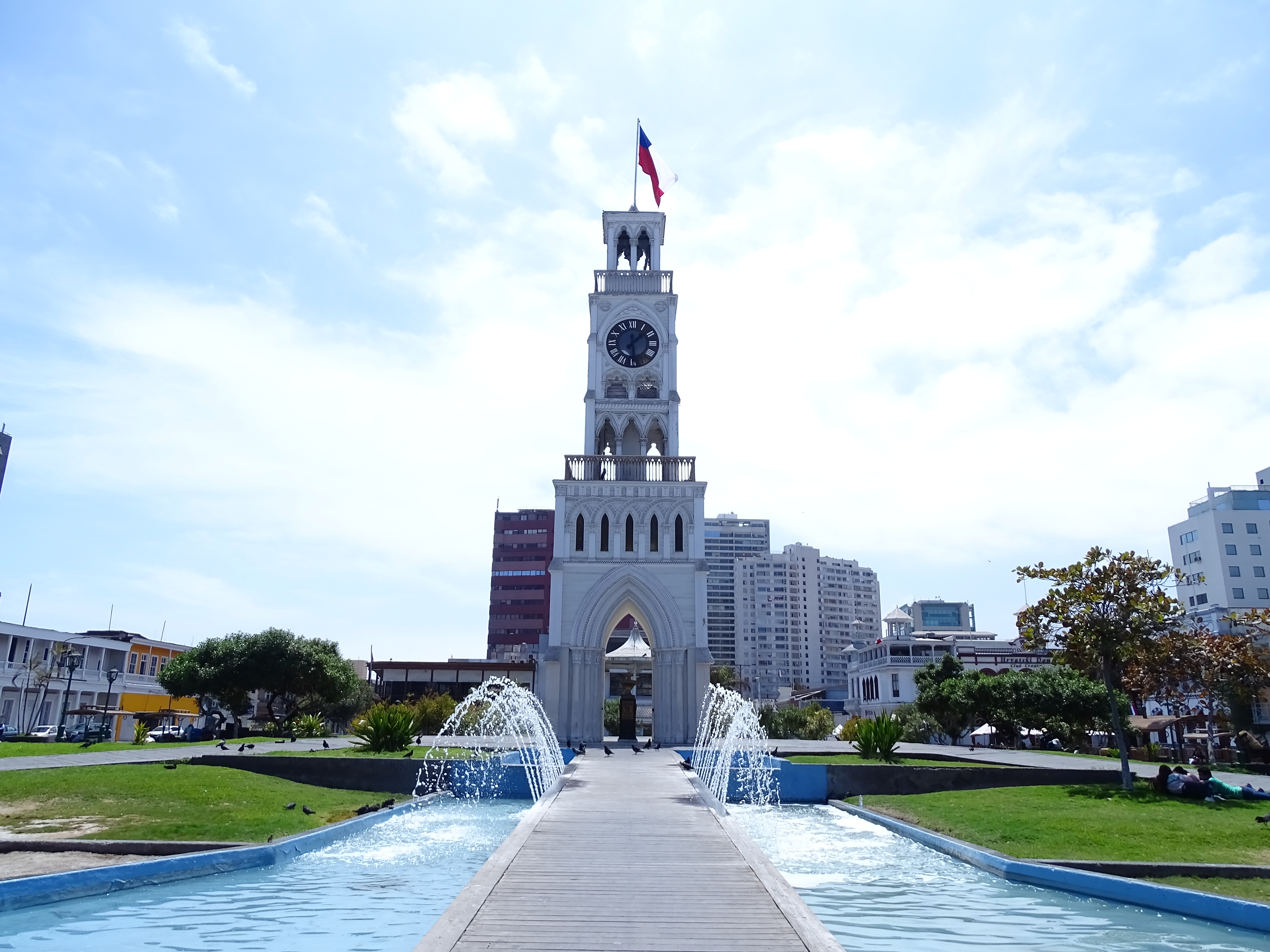 Banca y palmeras de la plaza con la torre de fondo
